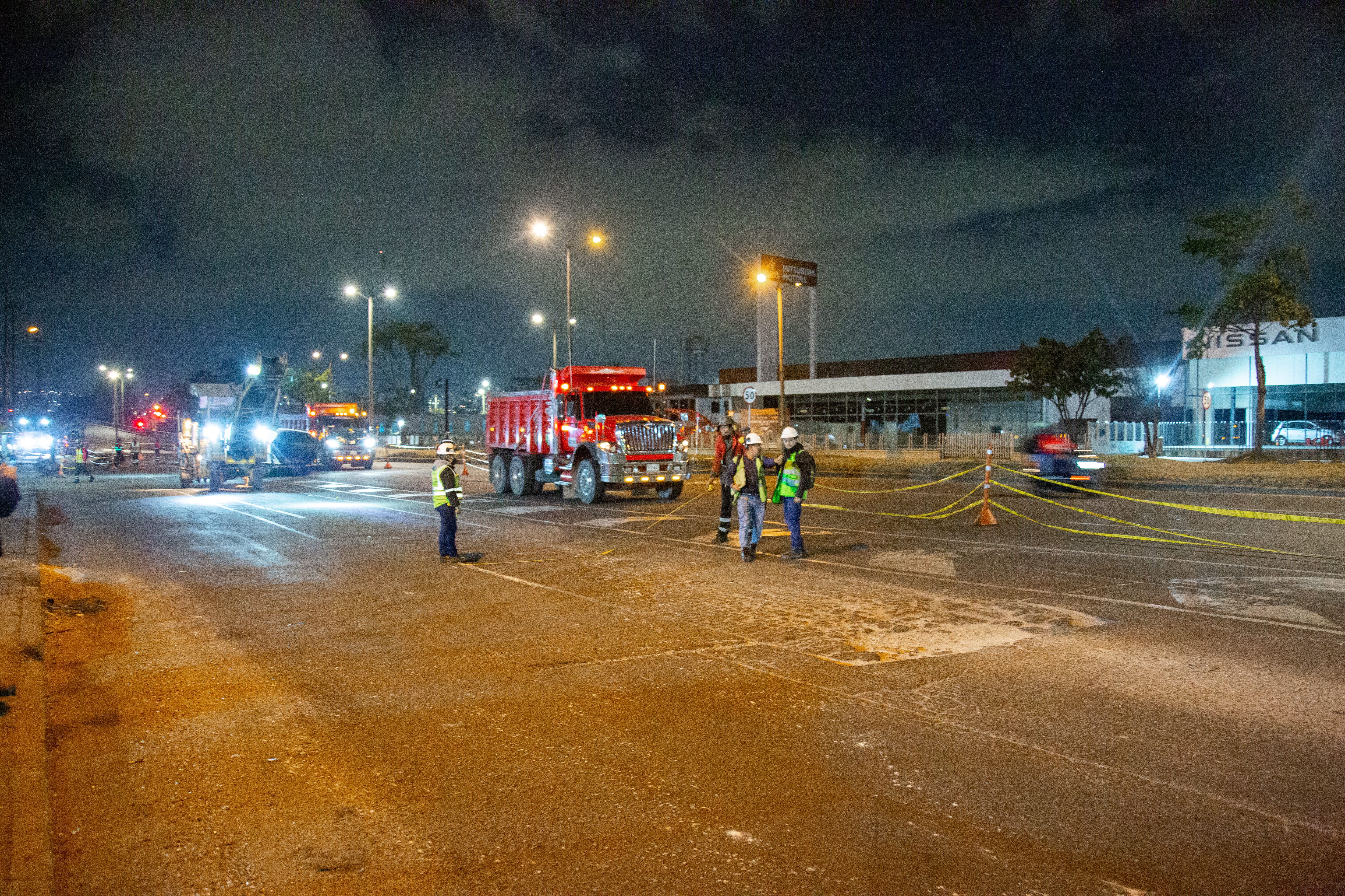 Un grupo de trabajadores de la obra observa uno de los huecos que se disponen a tapar durante la intervención nocturna