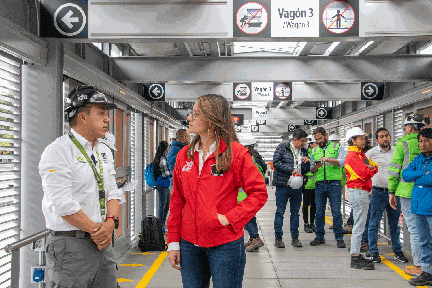 Adelante el director del IDU y la gerente de TransMilenio conversan. Destrás de ellos un grupo de personas de las dos entidades también intercambian conceptos