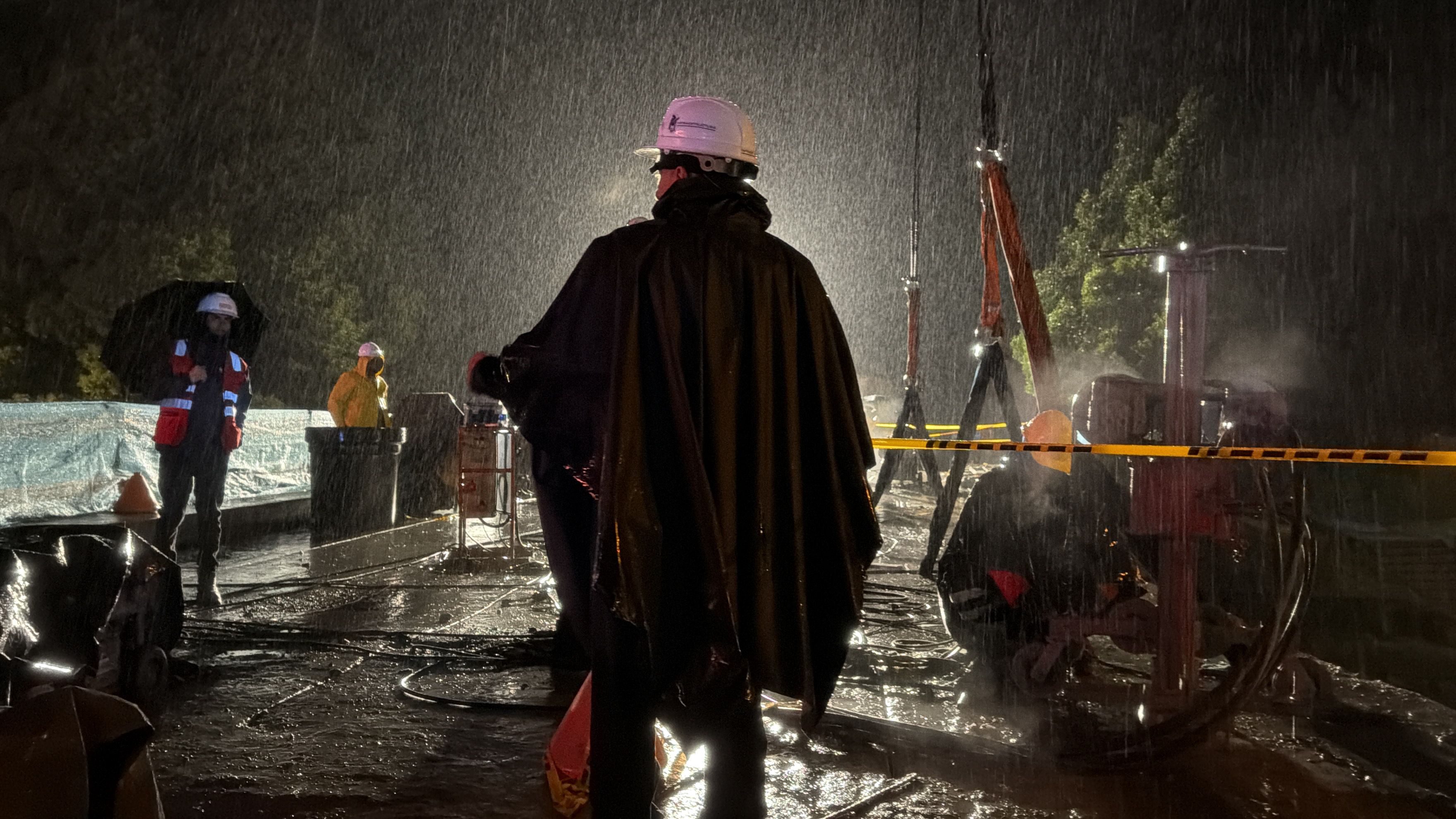 Operarios del IDU monitorean el área del puente de la carrera Séptima con calle 100 durante intensas lluvias nocturnas.